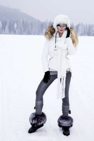 Young woman winter portrait. Winter fashion model with ski suit and goggles. Attractive young woman...