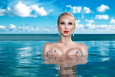 Sexy woman in bikini on the sun-tanned slim and shapely body is posing in the swimming pool - Image....