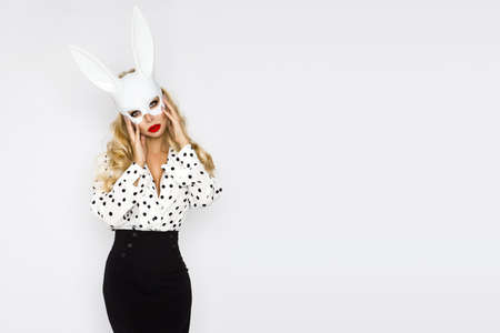 Fashion model. Sexy model in elegant black and white outfit with polka dots and in a white bunny mask isolated on white background. Masquerade. Sexy Girl in mask. Easter bunny concept.の写真素材