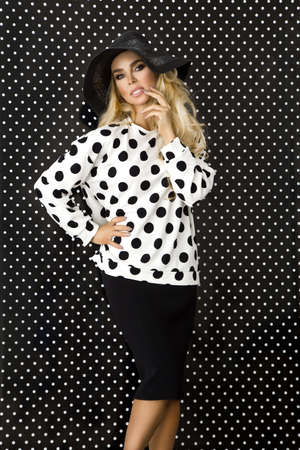 Beautiful model, dressed in a polka dots outfit on a polka-dot background. Polka dot fashion.の写真素材
