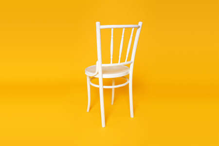 Wooden comfortable white chair isolated on yellow pastel background.の写真素材