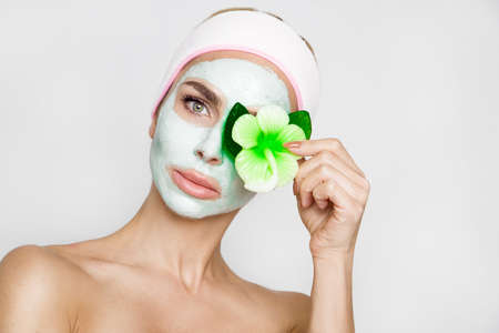 Beautiful blonde woman with moisturized face mask. Beauty spa. Skincare concept. Woman with facial mask.の写真素材