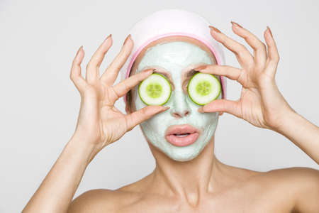 Beautiful blonde woman with moisturized face mask. Beauty spa. Skincare concept. Woman with facial...