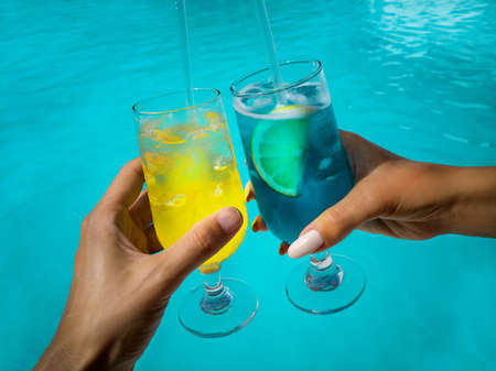 Healthy drink on a Caribbean beach. Colorful drinks handheld on the tropical beach among palm trees...