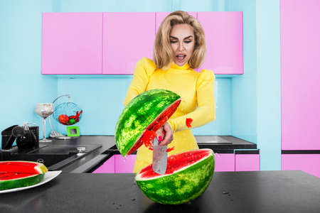 Beautiful woman cutting watermelon. Happy young woman in colored dress holding slice of a watermelon...