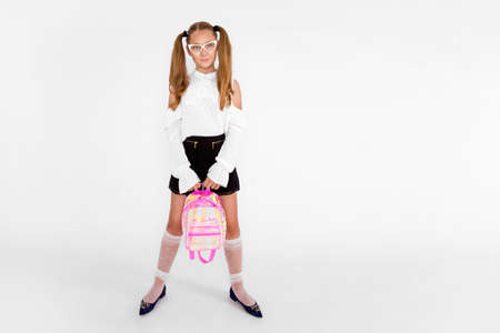 Girlish cute cheerful lovely stylish little girl with curly ponytails in formal blouse shirt, short black skirt. Isolated over white background. Back to school - Imageの写真素材