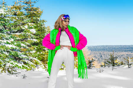Young woman winter portrait. Winter fashion model with ski suit and goggles. Attractive young woman in wintertime outdoor. Mountains, white snow in magic winter day.の写真素材