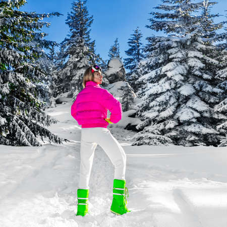 Young woman winter portrait. Winter fashion model with ski suit and goggles. Attractive young woman in wintertime outdoor. Mountains, white snow in magic winter day.の写真素材