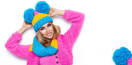 Image of happy young woman standing isolated over white background wearing warm scarf and beanie. Looking camera. Winter fashion.の写真素材