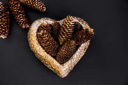 Autumn minimalist and simple composition in mat black and gold color. Winter decor, gold decorations on black background. Flat lay, top view with copy space. Autumn winter background.の写真素材