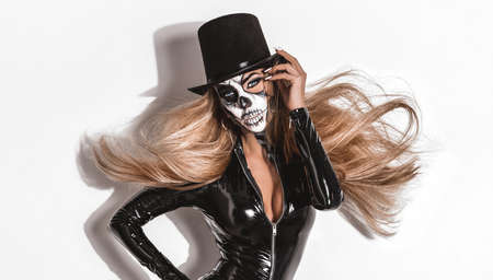 Female in Halloween silence. Sexy woman in top hat and skull make up. Halloween makeup.