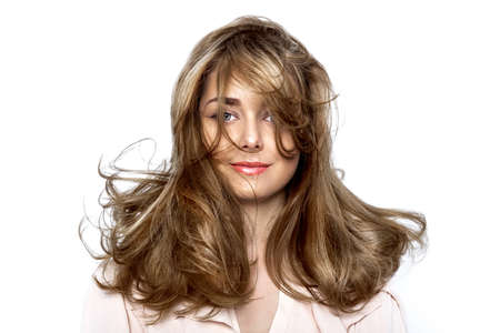 Portrait of a beautiful natural girl with beautiful healthy hair on a white background. A beautiful young girl with a perfect face and beautiful flowing hair. Beauty hair - concept.の写真素材