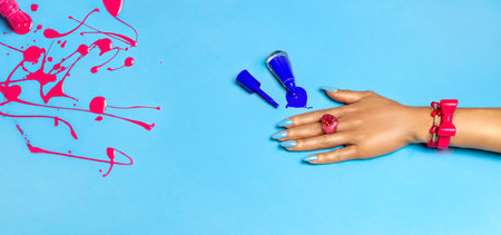Hand with a beautiful manicure on a blue background. Manicure and nails concept. Trendy nails.の写真素材
