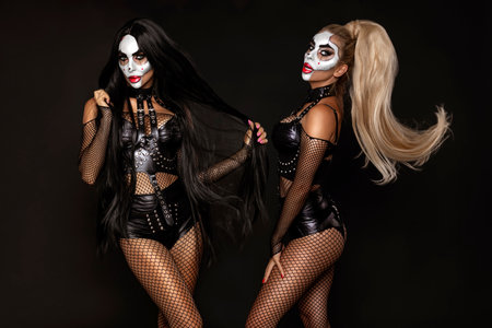 Sexy woman in a Halloween makeup and latex costume on black background. Halloween makeup and costume...