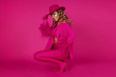 Pink fashion look featuring a glamorous woman in an outfit with a hat, gloves, and high...