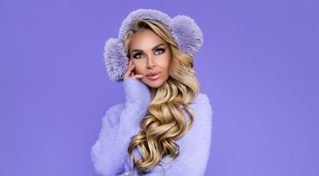 Elegant Fashion Woman in Pastel Lilac Faux Fur Coat and Hat on Matching Purple Background, Trendy Winter Monochrome Style Portraitの写真素材