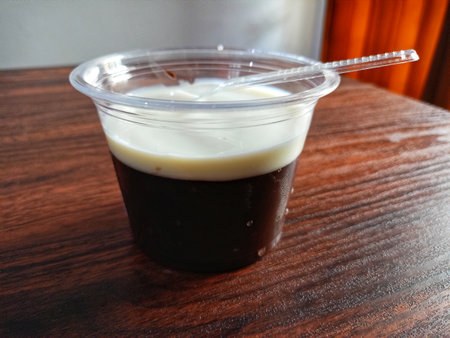 Chocolate pudding and milk in a cup on a wooden tableの写真素材