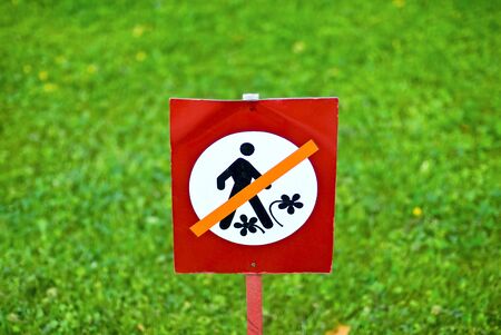 Keep off grass (flowers) sign over green grassの写真素材