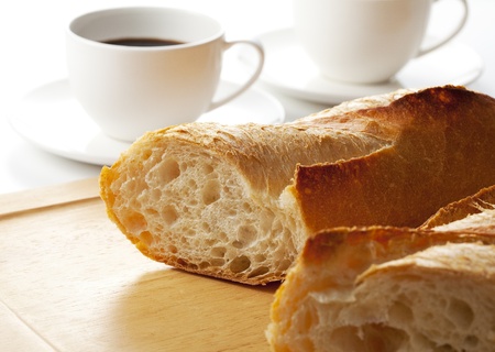 French bread and white cup of black coffee