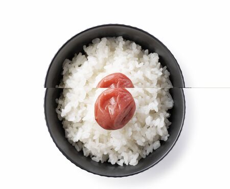 A bird's eye view of Japanese pickled plums and freshly cooked rice on a white backgroundの写真素材