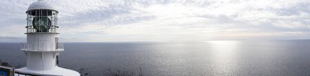 Panoramic photo of the lighthouse and the sea at duskの写真素材