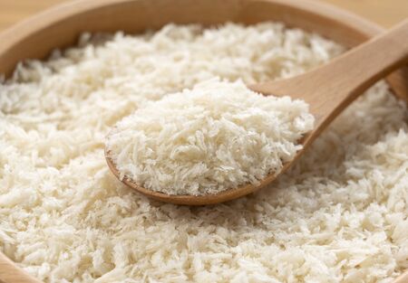 Close-up of spooning crumbs in a wooden bowl set against a wooden backdropの写真素材