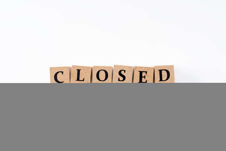 A block of wood with closed letters on a white backgroundの写真素材
