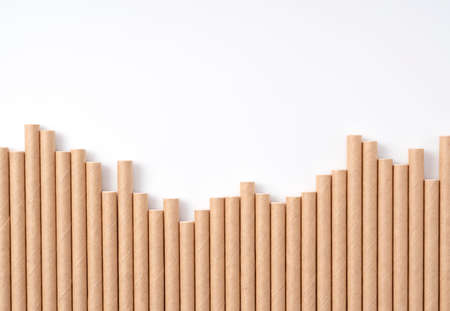 Paper straws lined up on a white background with copy space