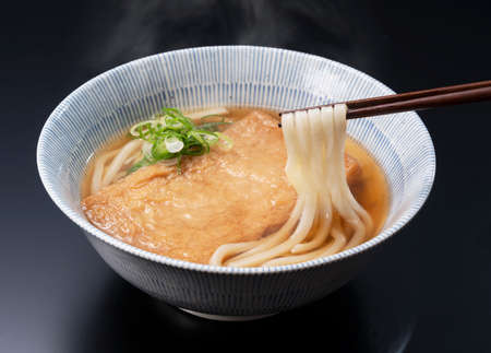 Udon noodles in a hot soup with deep fried tofu