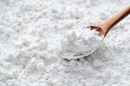 A wooden spoon on the potato starch that covers the entire screenの写真素材