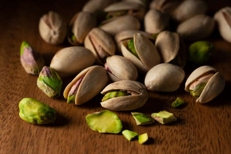 Close-up of a pistachio placed against a wood grain background