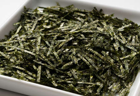 Close up of chopped seaweed on a white background
