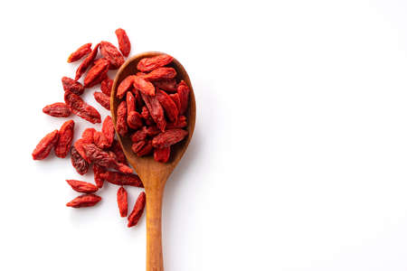 Wolfberries on a wooden spoon on a white background with copy space. View from directly aboveの写真素材
