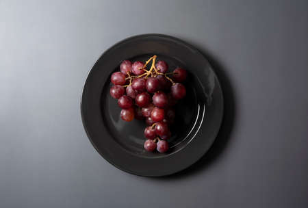 Red Globe served on a plate set against a gray background. View from directly above.