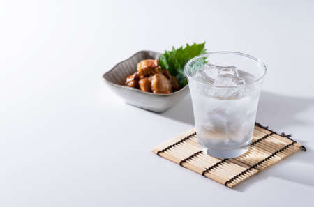 Shochu and nibbles on a white background with a copy space. Image of Japanese liquor.の写真素材