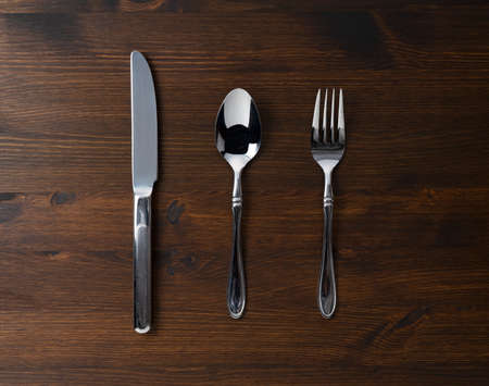 A spoon, fork and knife on a wooden table. View from above.の写真素材