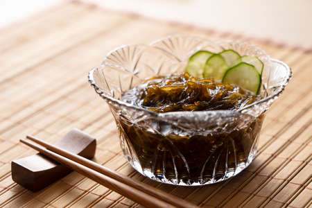 Mozuku placed on a bamboo wanchong mat.  The image of Japanese food.Mozuku is an Okinawan delicacy. It is a kind of dark, thread-like seaweed seasoned with vinegarの写真素材
