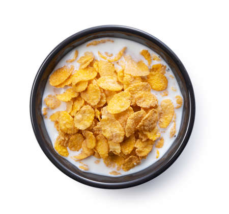 Milk and cornflakes in a black bowl. View from directly above.