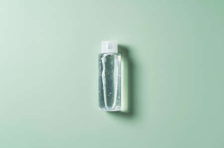 Sanitizing gel placed on a pastel green background. View from directly above.