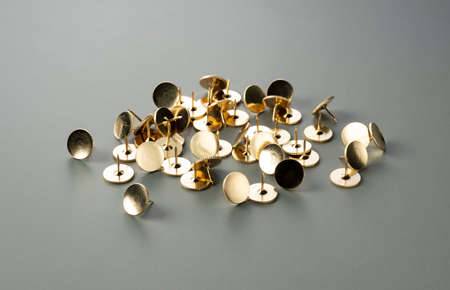 Gold thumbtacks placed on a green background