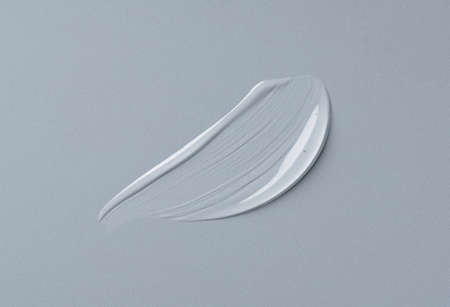 Transparent gel drop on gray background. Liquid gel cosmetic stain texture. Beauty serum drop....
