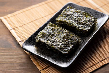 Korean seaweed served on a plate on a wooden table.