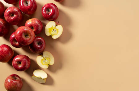 A lot of apples placed on a beige background, cut in half or quarter. Composition seen from above.の写真素材