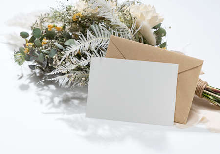 Dried flower bouquet and blank message card placed on white background. Wedding and celebration...