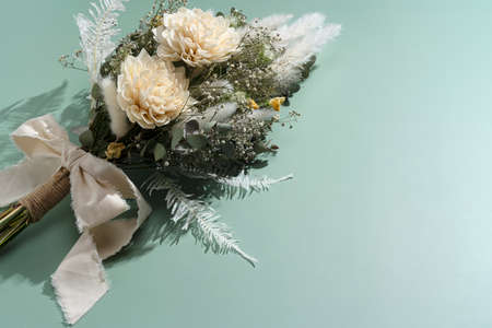Bouquet of dried flowers placed on green background. Wedding and celebration concept.の写真素材