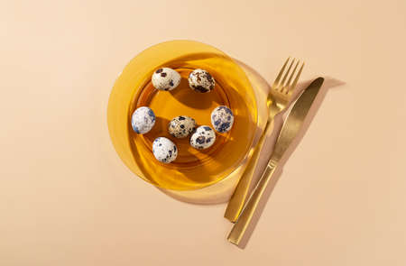 Quail eggs in a glass dish placed on a beige background. An image of the dish. View from above.の写真素材