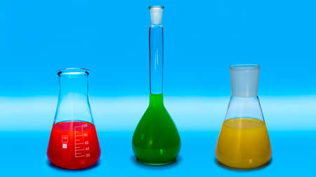 Laboratory glass chemical flasks with multi-colored liquids on a blue background. Laboratory...