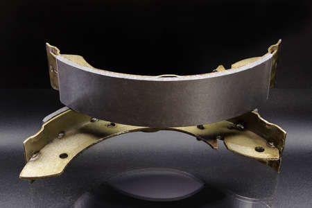 Drum brake pads with reflection on the surface on a black background. Car brake system repairの写真素材