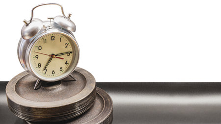 Time for morning workout. Classic alarm clock standing on bar pancakes. Conception of sports and healthy lifestyleの写真素材