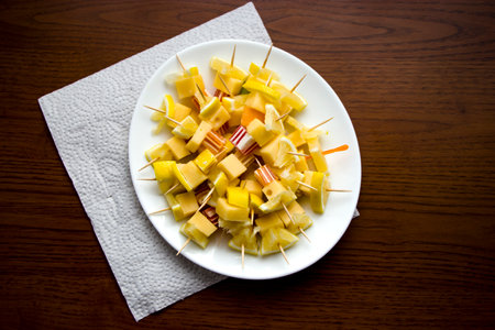 Canapes with cheese, lemon and marmalade on a white plate. Wooden table background. Fresh and healthy food. Diet.の写真素材